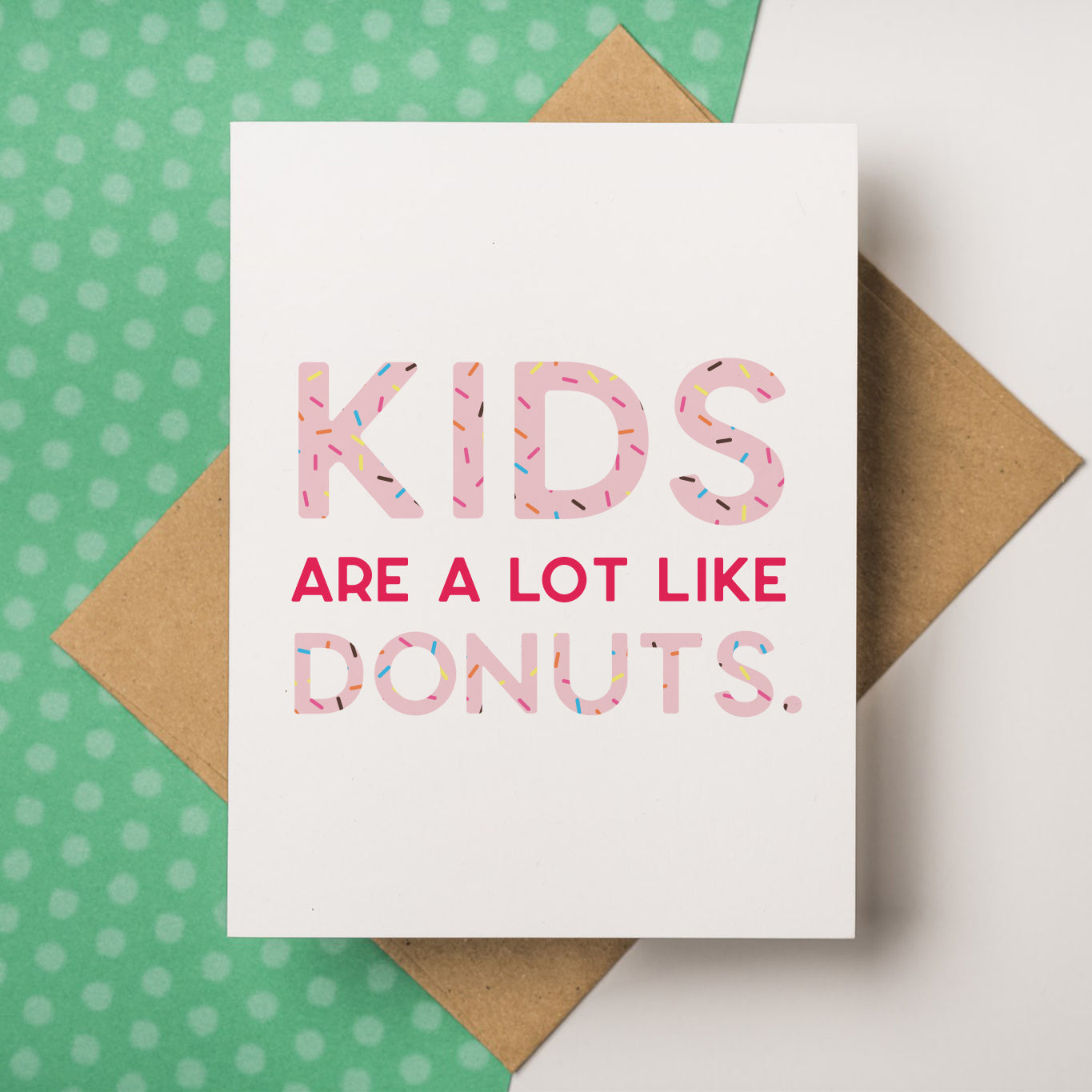 A funny and unique baby and parenthood greeting card that reads "Kids are a lot like donuts." on the front side,